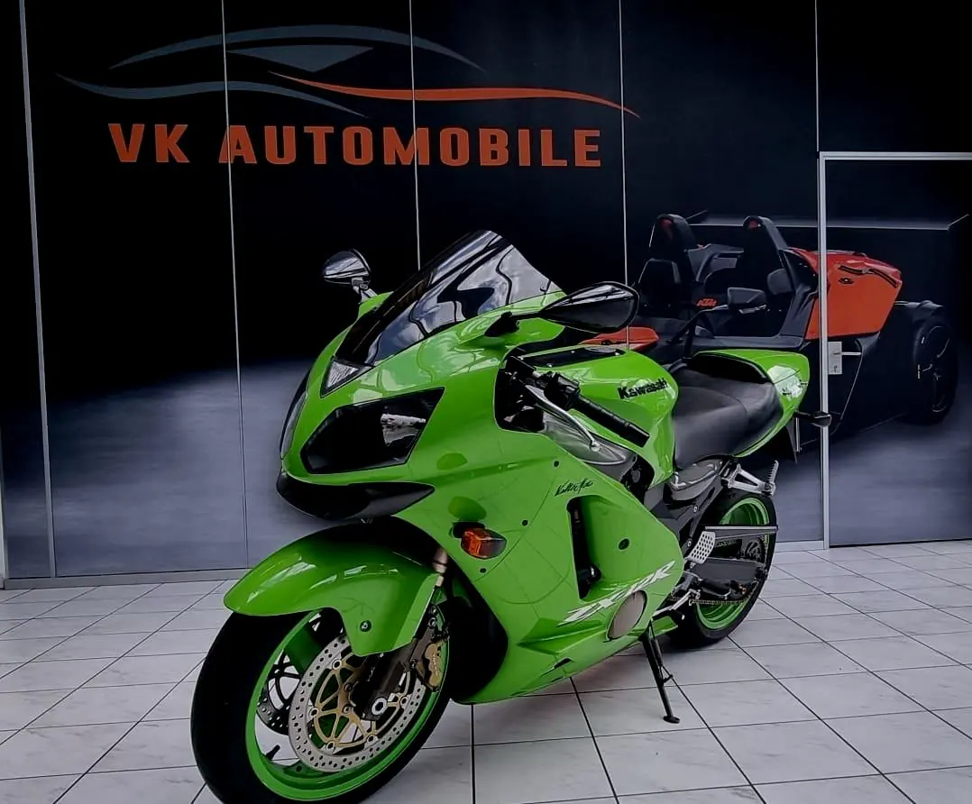Grüne Kawasaki vor der VK-Automobile-Wand